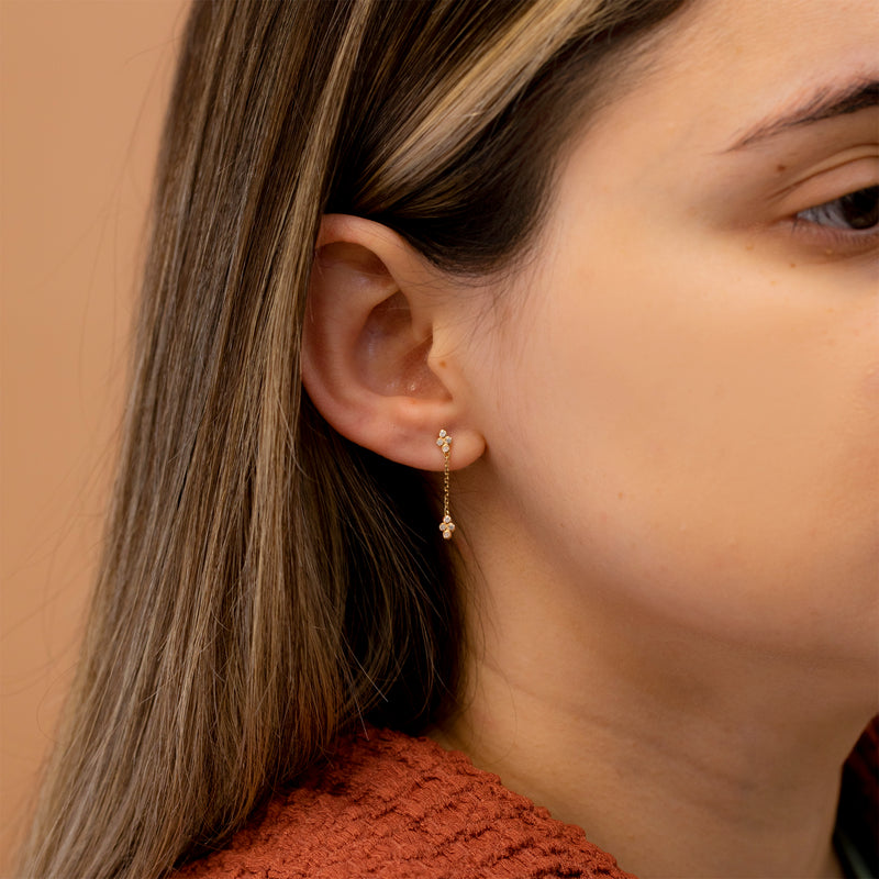 Model wears petite diamond chain stud earring with clover diamond cluster