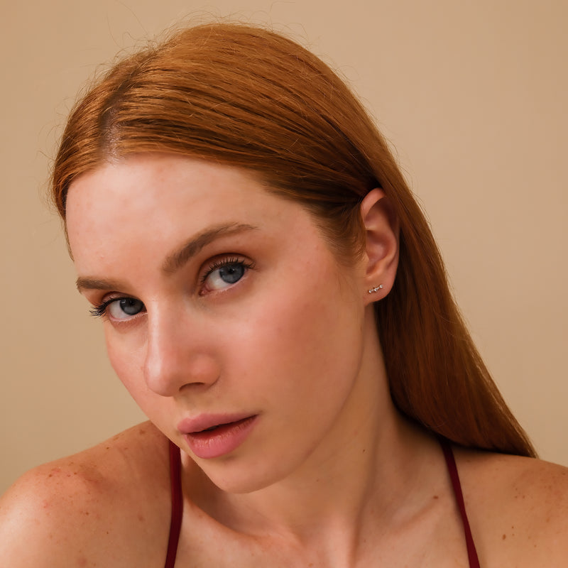 Model wears curved bar stud earrings with multiple diamonds gift for her