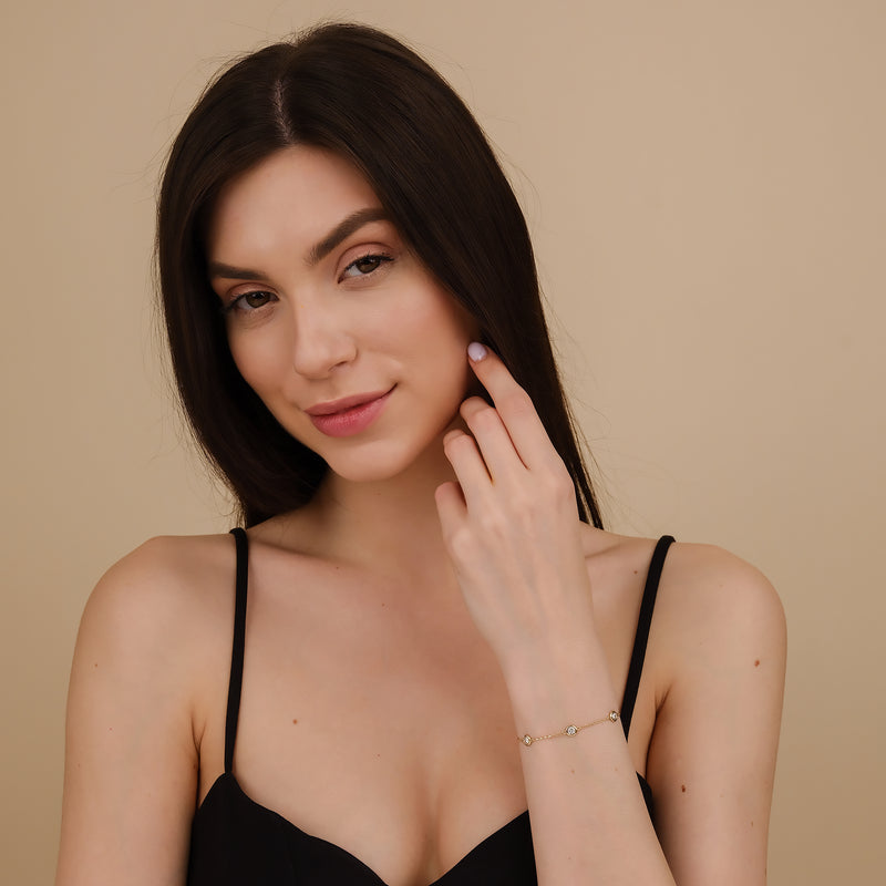  A woman's wrist wearing a gold diamond by the yard bracelet.