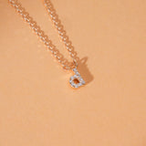 Close-up of diamond initial pendant featuring a sparkling diamond on a delicate gold chain.