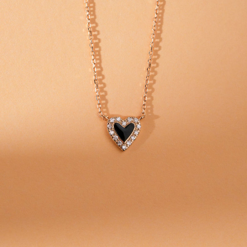 Bold two-tone heart pendant necklace with diamond accent and black enamel.