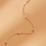 minimalist solid gold bracelet with several mother of pearl stationed beads