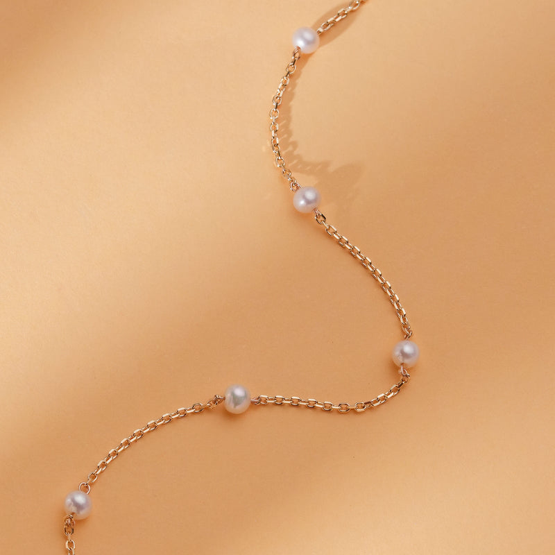 minimalist solid gold bracelet with several mother of pearl stationed beads