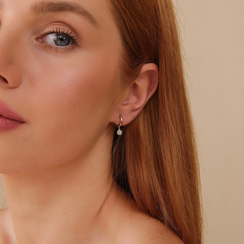 Model wears petite minimalistic design diamond disc paved huggies gift for her