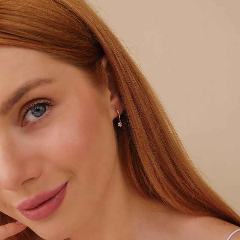 Model wears minimalistic star shaped huggie hoops gift for her