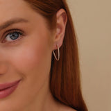 Model wears april birthstone clear diamond wavy hoop earring gift for her