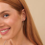Model wears natural diamond solid 14k gold diamond stud earring with hanging cuban chain 