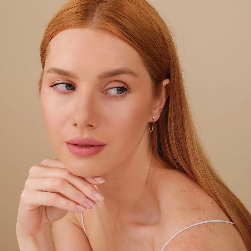 Model wears diamond stud earring with hanging Curb Chain in 14k solid gold April birthstone gift for her. 