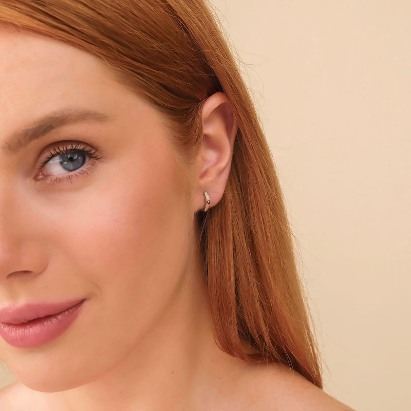 Model wears 14k solid gold spiked pyramid huggie hoop