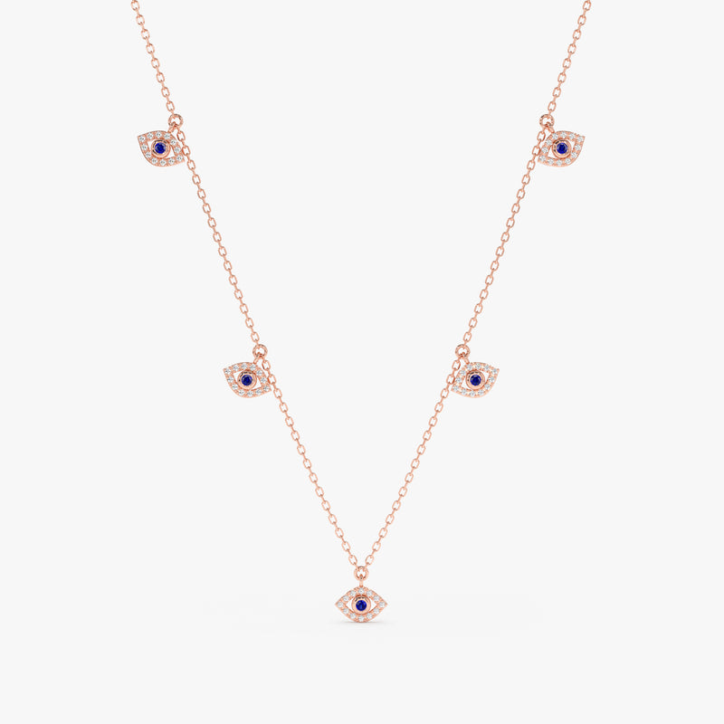 handcrafted solid rose gold necklace with multiple hanging eye charms in lined diamonds and blue sapphires