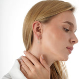 Yume Infuse your style with the geometric precision and elegant symbolism of our Baguette Diamond Cross Huggie Hoops. This striking pair is meticulously crafted in lustrous solid gold, featuring a dazzling cross pendant formed by sleek baguette-cut lab-gr