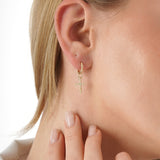 Yume Infuse your style with the geometric precision and elegant symbolism of our Baguette Diamond Cross Huggie Hoops. This striking pair is meticulously crafted in lustrous solid gold, featuring a dazzling cross pendant formed by sleek baguette-cut lab-gr