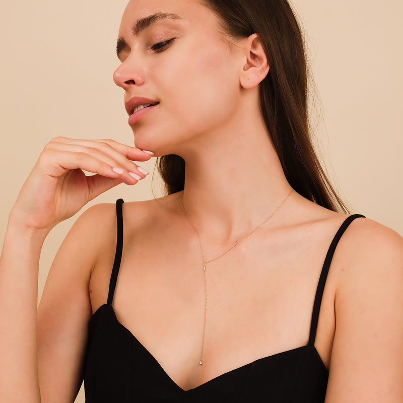 Gold lariat necklace with a vertical diamond-accented bar pendant