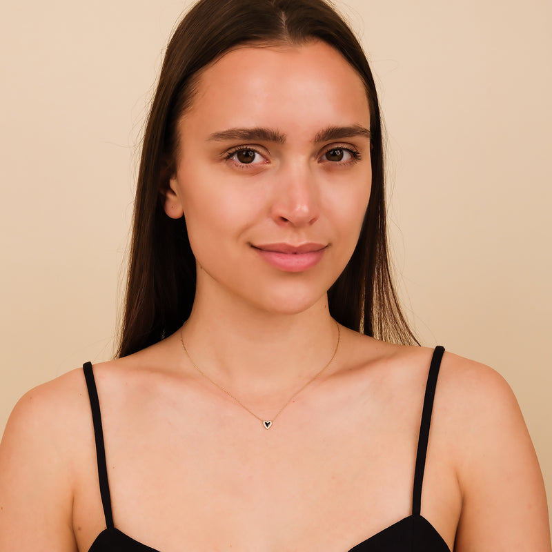 Black and gold heart necklace with pave diamond detail.