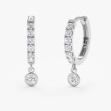 Handcrafted pair of solid 14k white gold diamond lined hoop earrings with hanging diamond bezel