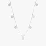 Mixed coin necklace featuring polished metal disks and sparkling diamond pave disks on a delicate chain.