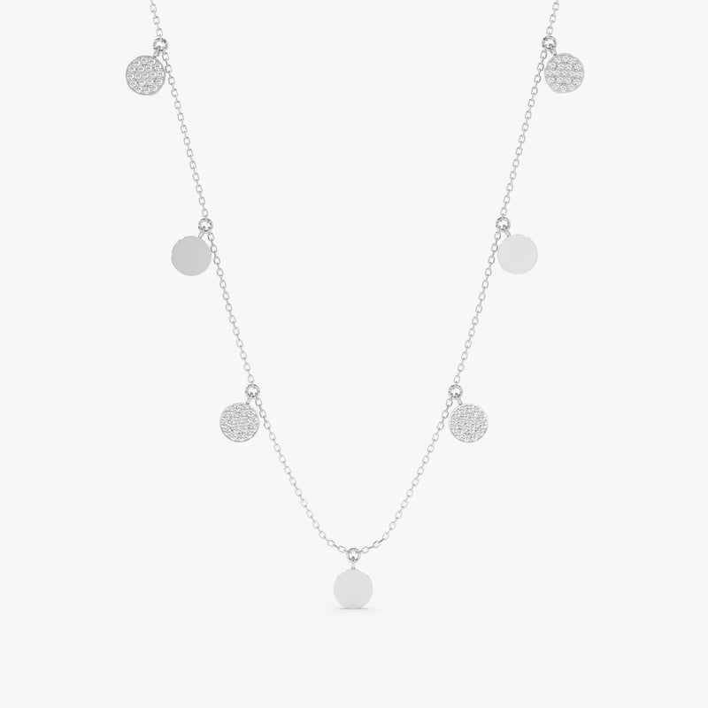 Mixed coin necklace featuring polished metal disks and sparkling diamond pave disks on a delicate chain.