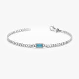 Gold Cuban chain bracelet with bezel-set London blue topaz.