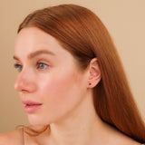Model wears dainty handmade 14k solid gold black diamond bezel stud earrings
