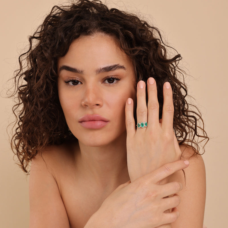 three oval emeralds with diamond accents proposal band