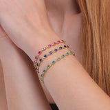 Gold garland style tennis bracelet featuring natural diamonds and gemstones