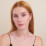 dainty solid gold necklace with five hanging star charms in diamonds