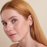 model wears emerald stud earring with lined diamonds