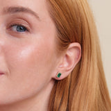 model wears dainty emerald cut stud earring with lined diamonds in solid gold