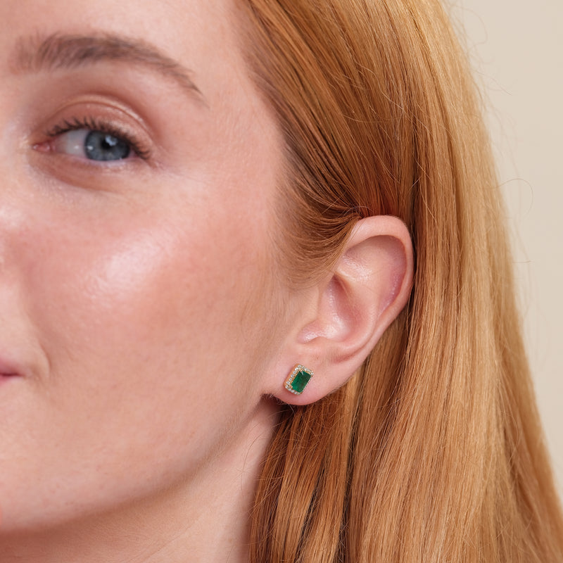 model wears dainty emerald cut stud earring with lined diamonds in solid gold