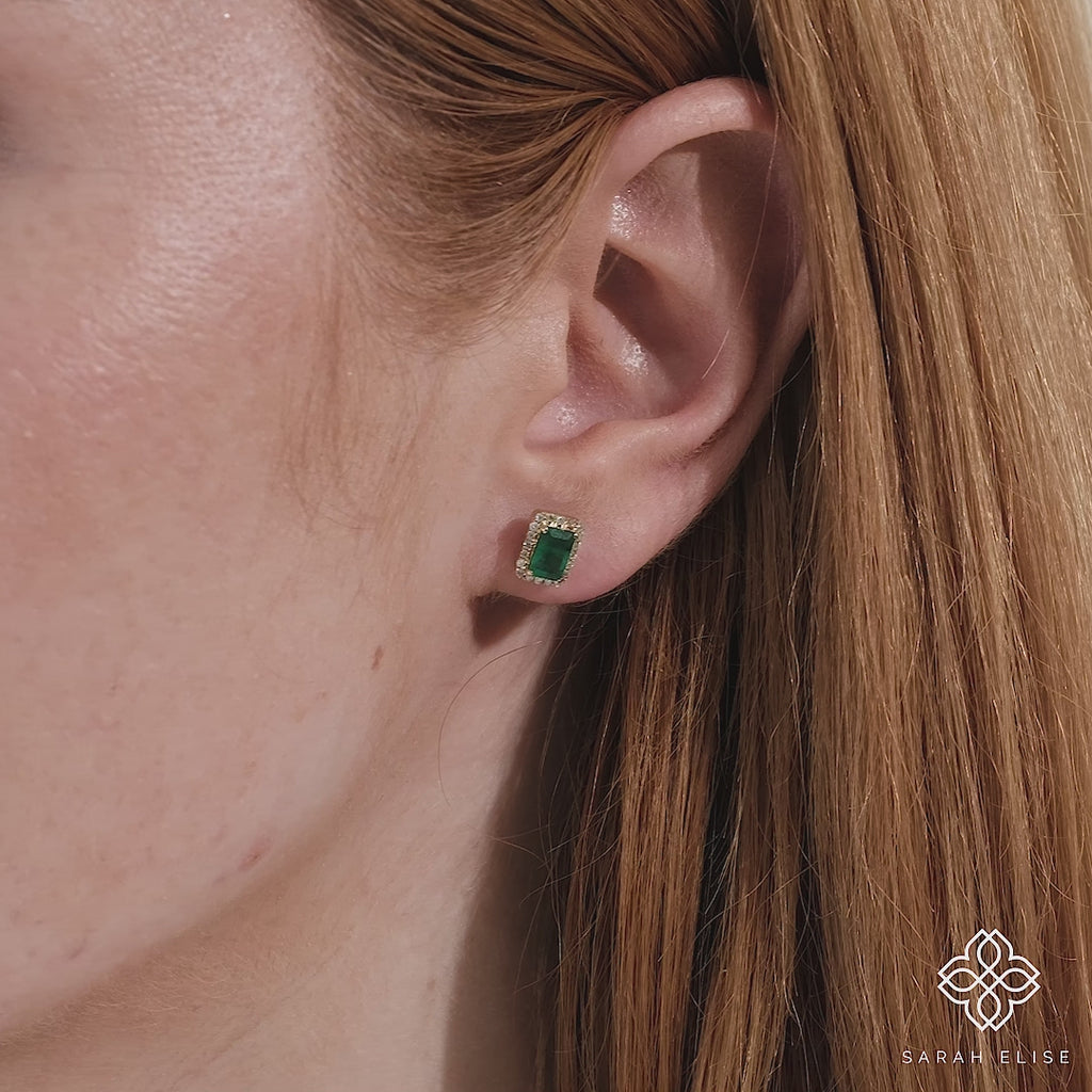 Video close up of model wearing dainty emerald studs with lined diamonds for her