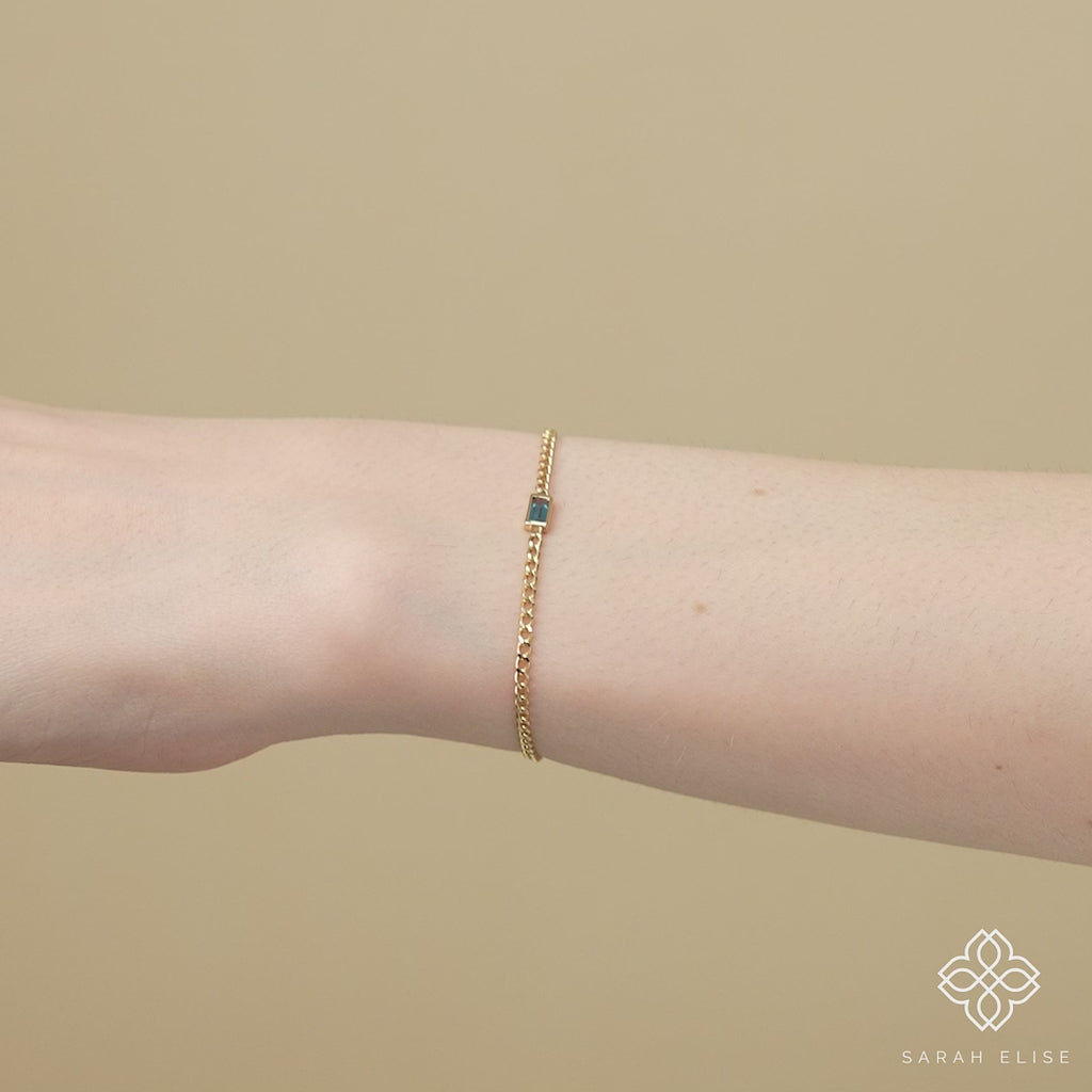 Dainty London blue topaz bracelet on a delicate gold Cuban chain, perfect for December birthdays.