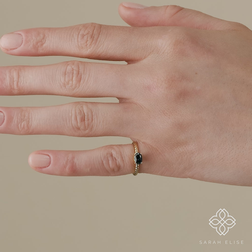 twisted solid gold ring with oval cut teal blue sapphire 