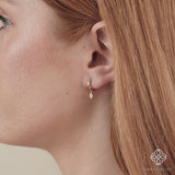 Video close up of ethically sourced fine jewelry huggies with paved diamond disc in solid 14k gold