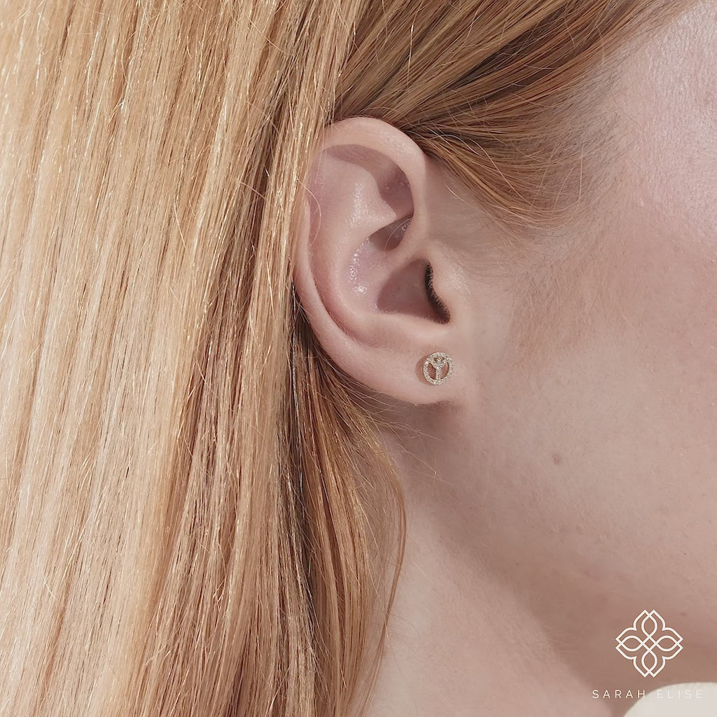 Video close up of peace sign earring stud with April birthstone diamonds gift for her in 14k gold. 