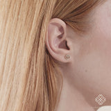 Video close up of peace sign earring stud with April birthstone diamonds gift for her in 14k gold. 