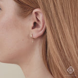 Video close up of ethically sourced star shaped huggie charm earring