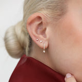 Model wears dainty Diamond cluster Studs and Dangling Hoop