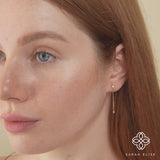 Model wears petite long hanging diamond bezel earring stud