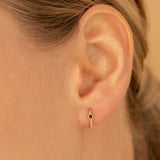 Model close up of Dainty red Garnet Huggies in solid gold