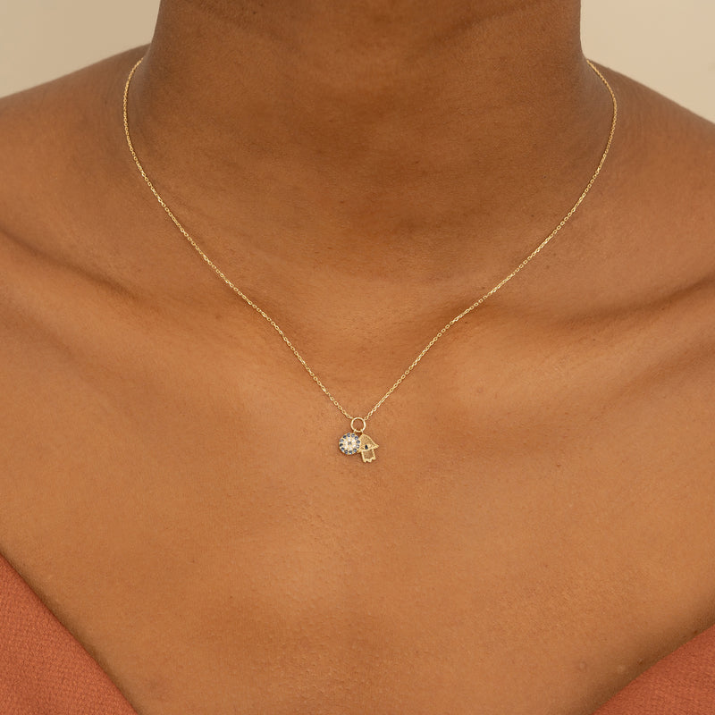 Stylish protective amulet featuring an Evil Eye and a Hamsa on a solid gold necklace.