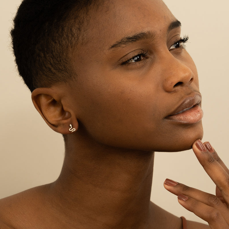 Model wears Tiny Diamond encrusted Snake Stud earrings