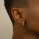 Model wears solid yellow gold U shape hoop huggie earring 