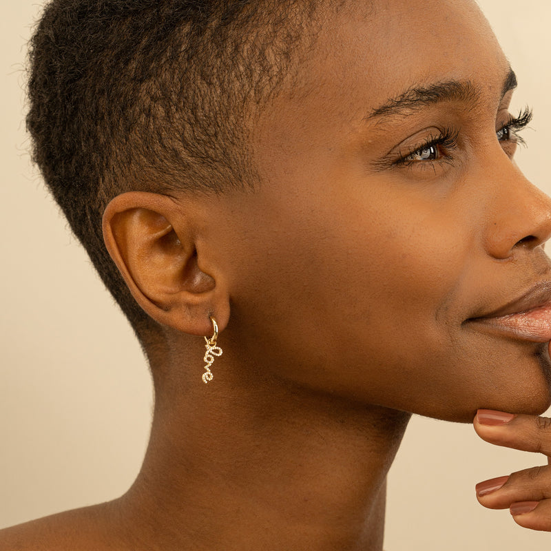 Model wears minimalist Diamond Love Huggie Hoop earring