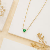 Heart-shaped emerald pendant on a gold chain.