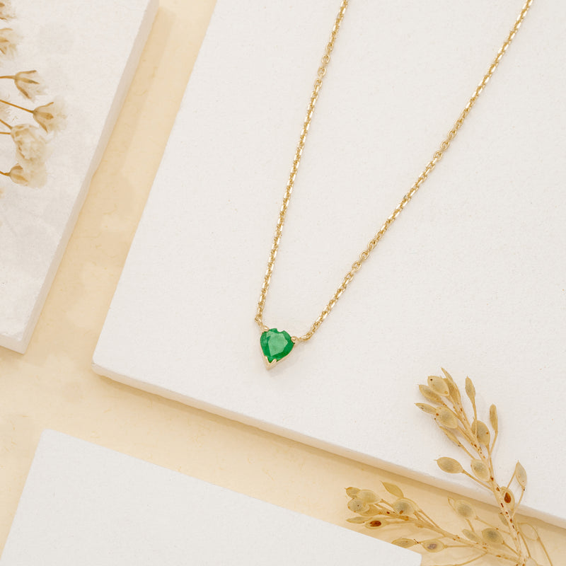 Heart-shaped emerald pendant on a gold chain.