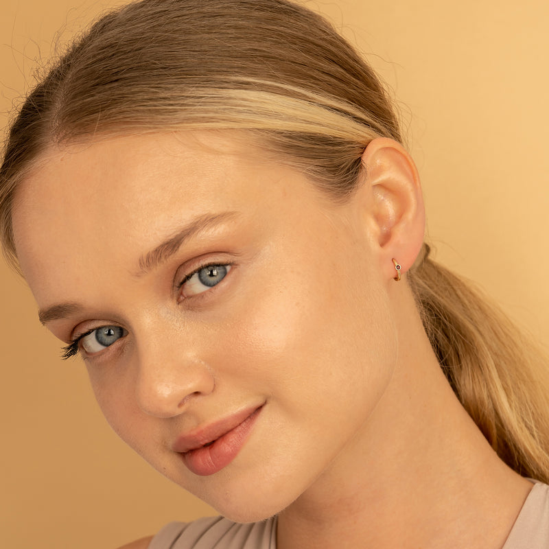 Model wears dainty Bezel Setting red Garnet January Huggies