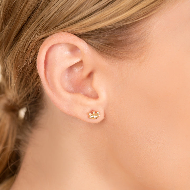 Model wears dainty eye stud earrings with diamond eyelashes