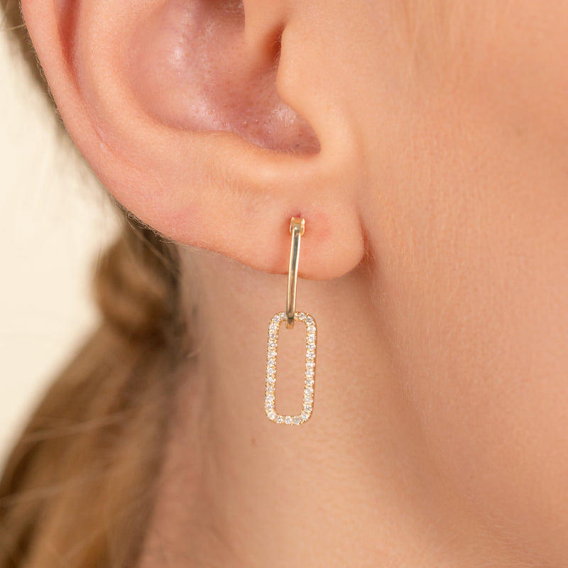 Model wears handmade pair of solid 14k gold hanging chain link earring with lined diamonds
