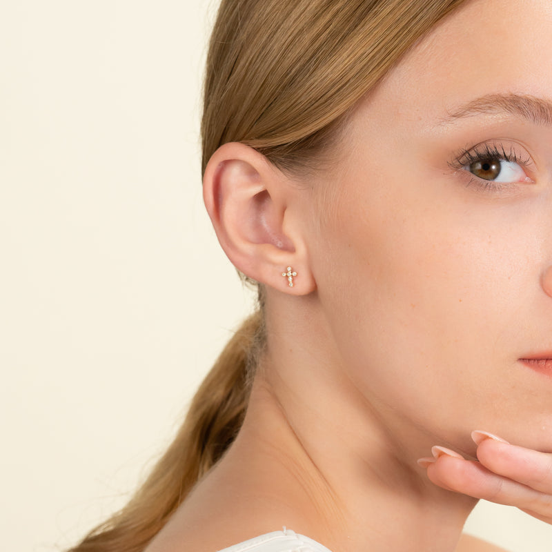 model wears dainty Diamond Cross Earrings with multiple diamonds