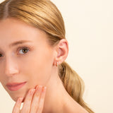 Model wears minimalist solid 14k gold hoop huggies